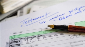 Ein Formular für die Erbschaftsteuererklärung sowie Stift und Testament liegen auf einem Tisch. (Symbolbild)