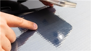 Ein Forscher des Fraunhofer ISE zeigt auf die Struktur der Solarzellen auf einer Motorhaube.