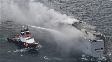 Ein Foto, das von einem Flugzeug der niederländischen Küstenwache aufgenommen wurde, zeigt den brennenden Frachter «Fremantle Highway» in der Nordsee. Der deutsche Notschlepper «Nordic» schießt Wasser auf den Rumpf, um die Bordwand zu kühlen.