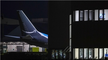 Ein Frachtflugzeug von Amazon Prime steht neben einem Bürogebäude auf dem Flughafen Leipzig-Halle.