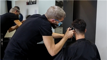 Ein Friseur schneidet die Haare eines Kunden in einem Friseursalon.