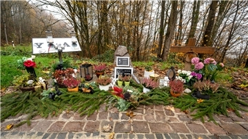 Ein Gedenkstein und Blumen sind in der Nähe des Tatorts an der K22 bei Kusel aufgestellt, wo Ende Januar 2022 zwei Polizisten im Dienst getötet wurden. 