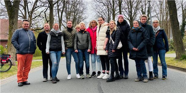 Männer und Frauen blicken in die Kamera.