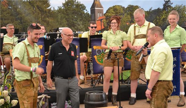 Ein Geschenk für die Gastgeber: Die Werrataler Torsten Thiemich (rechts) und Leon Kreuzberger (links) beschenken den Vorsitzenden des Kirchtimker Musikzuges, Andreas Klaffke (Mitte) mit einem Fass Bier und einem Satz Maßkrüge.
