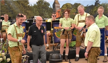Ein Geschenk für die Gastgeber: Die Werrataler Torsten Thiemich (rechts) und Leon Kreuzberger (links) beschenken den Vorsitzenden des Kirchtimker Musikzuges, Andreas Klaffke (Mitte) mit einem Fass Bier und einem Satz Maßkrüge.
