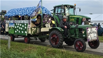 Festlich geschmückter Traktor mit Anhänger in einem Festumzug