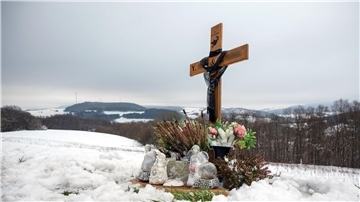 Ein Holzkreuz, Engelsfiguren und Blumen erinnern bei Kusel an die zwei Polizisten, die vor einem Jahr im Dienst getötet wurden.