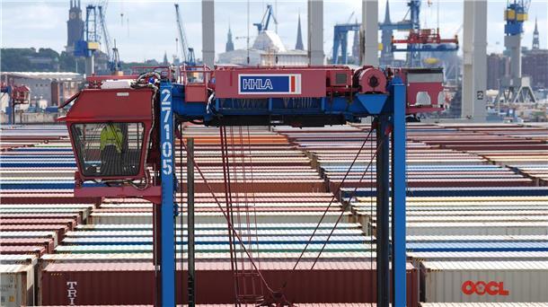 Hafenarbeiter sollen mehr Geld bekommen - keine Warnstreiks Ein Hubwagen fährt zwischen Containern im Hamburger Hafen umher. (Archivbild)