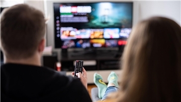 Ein junges Paar sitzt mit einer Fernbedienung vor einem Fernsehgerät. Nachrichten aus dem Fernsehen bleiben für die meisten die wichtigste Quelle. (Symbolbild)