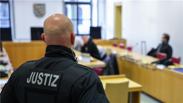 Jagd auf politische Gegner - Männer in Chemnitz vor Gericht Ein Justizbeamter steht vor Prozessbeginn vor einigen Angeklagten im Landgericht Chemnitz.