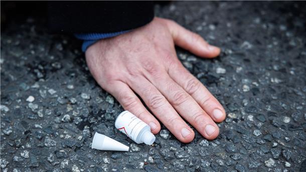 Ein Klimaaktivist hat sich am Stachus mit seiner Hand auf die Straße geklebt.