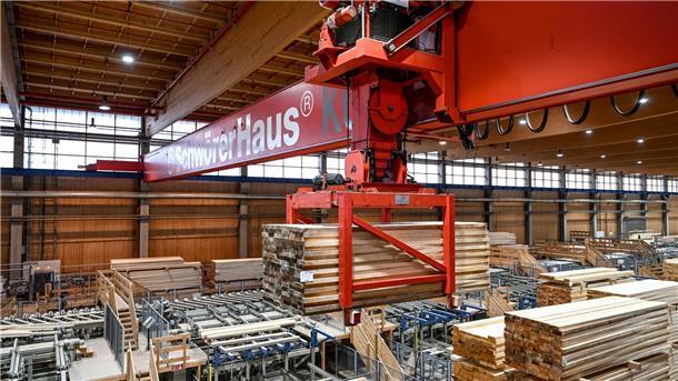 Nach dem Fertighaus-Boom: Kommt jetzt die Krise? Ein Kran hebt eine Ladung Holz an, um diese in einer Halle der SchwörerHaus KG zu einem anderen Platz zu transportieren.