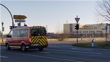 Es ist eine Kreuzung zu sehen, auf der ein Fahrzeug vor einer roten Ampel wartet. Rechts im Bild: Die Helios-Klinik Wesermarsch in Nordenham.