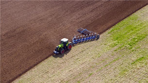 Ackerboden ist Boden des Jahres 2023 Ein Landwirt pflügt ein abgeerntetes Feld und bereitet es für die Neubestellung vor.