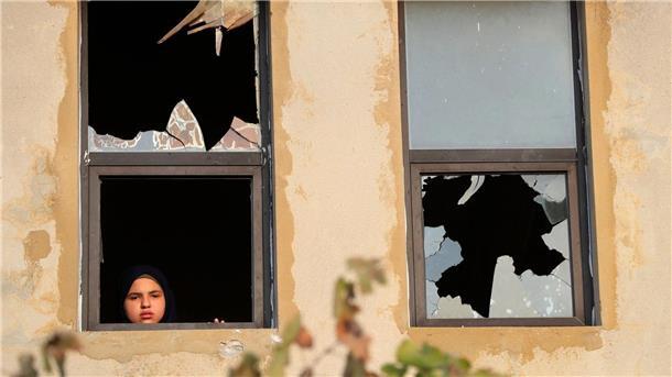 Vergeltung mit Raketen: Hisbollah feuert auf Israel Ein libanesisches Mädchen blickt nach israelischem Beschuss auf ein Dorf im Südlibanon durch ein zerbrochenes Fenster.