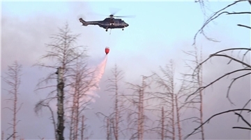 Ein Löschhubschrauber über dem Waldbrand in einem munitionsbelasteten Gebiet bei Jüterbog (Landkreis Teltow-Fläming).