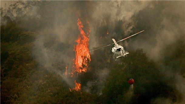 Hilfe für Brand-Opfer in Spanien - Viele Feuer lodern weiter Ein Löschhubschrauber wirft Wasser über einem Feuer in der spanischen Provinz Ourense ab.