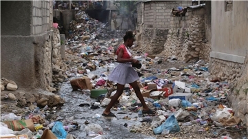 Ein Mädchen geht durch eine mit Müll gefüllte Häuserschlucht in Port-au-Prince. Bewaffnete Gruppen entführen dort zunehmend Kinder und Frauen - in den meisten Fällen zu finanziellen oder taktischen Zwecken.