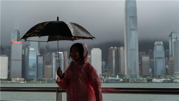 Bilder des Tages Ein Mädchen hält einen Regenschirm in Tsim Sha Tusi vor dem Victoria Harbor und der Skyline von Hongkong während des Taifuns „Tapah“.
