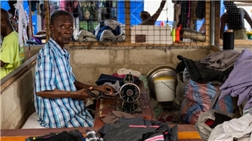 Ein Mann arbeitet auf einem Markt in Ghanas Hauptstadt Accra, wo unter anderem Kleidung aus Europa verkauft oder weiterverarbeitet wird.