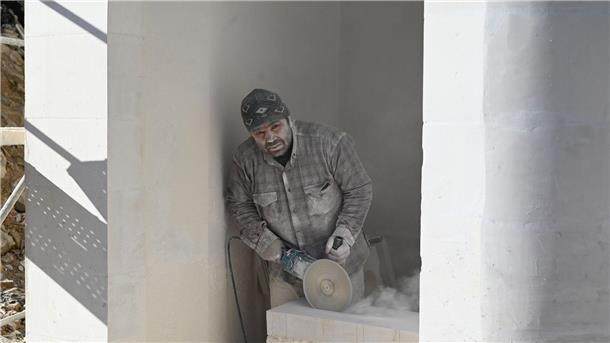 Feiern im Schutt - Das Leben nach dem Erdbeben in der Türkei Ein Mann arbeitet auf einer Baustelle in Antakya.