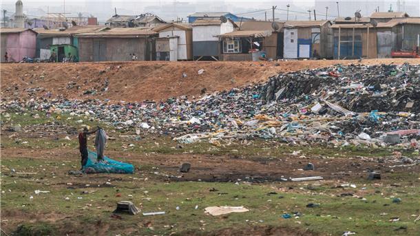 Schattenseiten der Modewelt: Riesiger Kleidermarkt in Accra Ein Mann auf einer Mülldeponie - hier liegt unter anderem Abfall aus Deutschland.