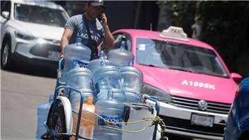 Ein Mann geht mit leeren Wasserkanistern durch eine Straße in Mexiko-Stadt. In 27 der 32 Bundesstaaten in Mexiko liegen die Temperaturen bei mehr als 40 Grad.