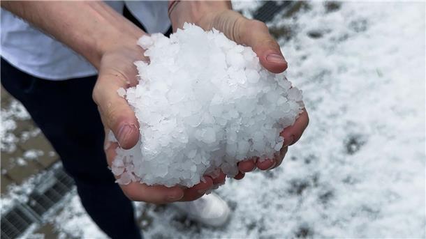 Unwetter sorgt für winterliche Verhältnisse in Südbaden Ein Mann hält einen Haufen großer Hagelkörner in seinen Händen.
