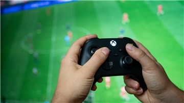 Ein Mann hält einen Kontroller der Spielekonsole Xbox Series X in der Hand.