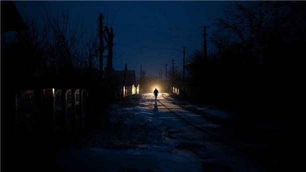 Krieg gegen die Ukraine: So ist die Lage Ein Mann ist während eines Stromausfalls in Kolytschiwka im Scheinwerferlicht eines Autos zu sehen.