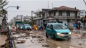 Ein Mann säubert die Straße nach dem Hochwasser in Volos.