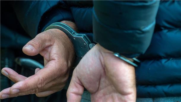 Falsche Polizisten in Peine festgenommen Ein Mann trägt Handschellen.