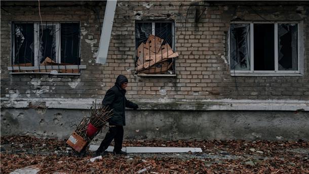 Krieg gegen die Ukraine: So ist die Lage Ein Mann trägt in Awdijiwka Reisig für einen Holzofen zum Keller eines Wohnhauses, der als Bunker genutzt wird.