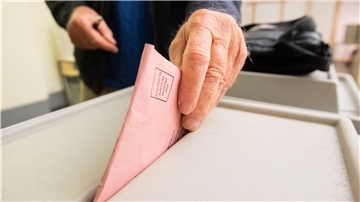 Ein Mann wirft seinen Stimmzettel in eine Wahlurne.