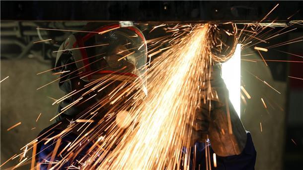 Auftragsflaute bei Deutschlands Maschinenbauern Ein Maschinenbauer während seiner Arbeit mit einem Trennschleifer.