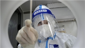Ein medizinischer Mitarbeiter in Schutzkleidung während er einen PCR-Test zum Nachweis des Coronavirus durchführt.