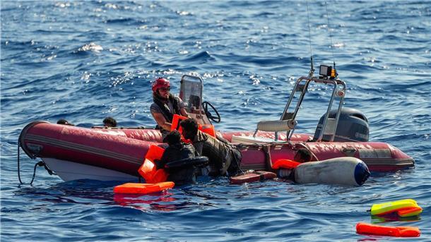 Flucht übers Mittelmeer: 289 Minderjährige gestorben Ein Mitglied der spanischen Nichtregierungsorganisation Open Arms hilft Migranten, an Bord zu kommen. Viele Minderjährige sterben während der Flucht.