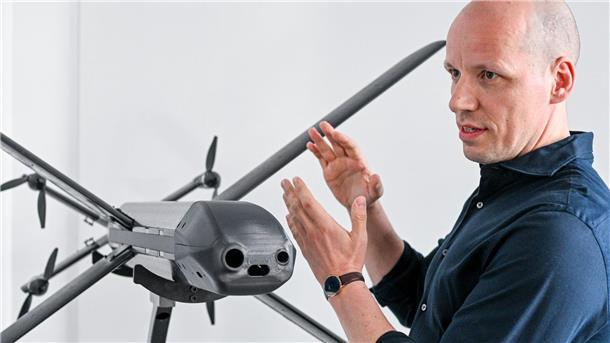 Ein Modell der HX-2-Drohne von Helsing, daneben der Mitgründer und Co-Firmenchef Gundbert Scherf.