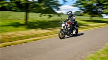 Ein Motorradfahrer fährt mit einem 125ccm-Bike über eine Landstraße.