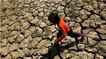 Ein philippinisches Kind läuft in der Provinz Cavite auf den Philippinen in einem ausgetrockneten Bewässerungskanal, der durch das Wetterphänomen „El Niño“ ausgetrocknet war.