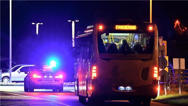 Ein Polizeiauto eskortiert einen Bus mit Menschen vom Flughafen Hamburg.