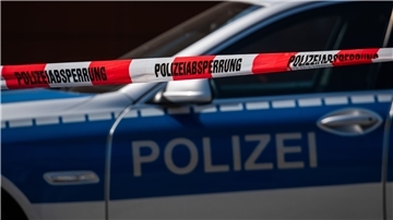 Ein Polizeiauto steht hinter einem Absperrband der Polizei.