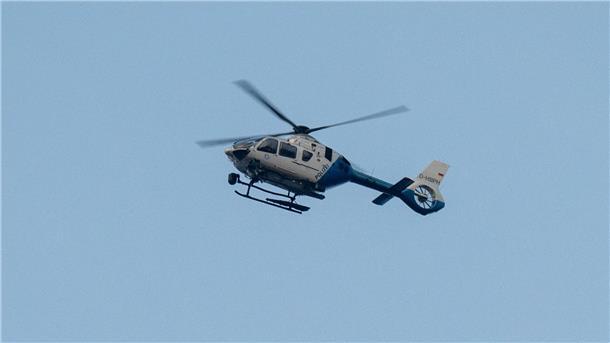 Ein Polizeihubschrauber fliegt über den Ortsrand in Parsberg.