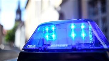 Das Blaulicht eines Polizeiautos leuchtet.