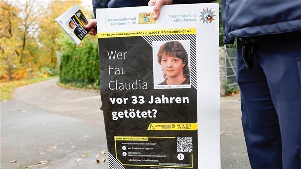 Ermittler rollen Mordfall nach 33 Jahren neu auf Ein Polizist mit einem Plakat zum Mordfall von 1990 in Röthenbach an der Pegnitz.