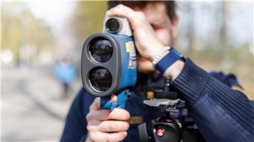 Ein Polizist schaut während des sogenannten Blitzmarathons durch ein Laserhandmessgerät.