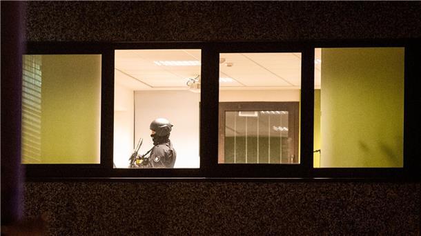 Amoktäter bei Zeugen Jehovas ist Ex-Gemeindemitglied Ein Polizist steht mit einer Waffe in einem Gebäude.