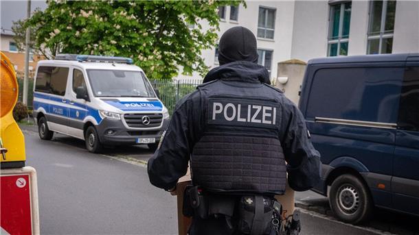 Razzia gegen Schleuser in NRW fortgesetzt Ein Polizist trägt bei einem Einsatz in Bonn einen Karton mit beschlagnahmtem Material aus einem Gebäude.