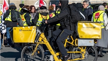 Ein Postbote radelt in Bielefeld an Streikenden einer Verdi-Aktion vorbei (Archivbild). Für die Post ist die Gefahr eines unbefristeten Arbeitskampfes noch nicht gebannt.