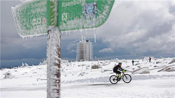 Winter im April - auch neue Woche wird kalt Ein Radfahrer ist auf dem schneebedeckten Brocken unterwegs.